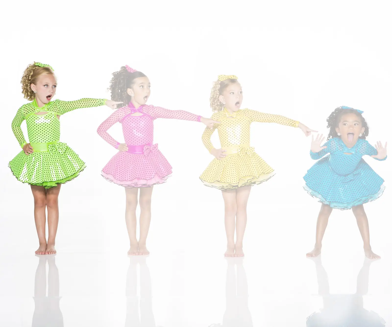 Four girls in colorful polka-dot dance costumes posing playfully