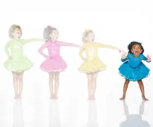 Four girls in colorful polka-dot dance dresses pointing right