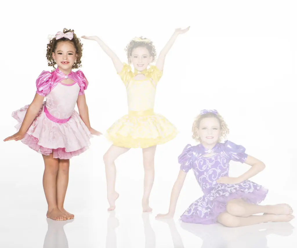 Three young girls posing in colorful princess dresses