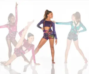 Four young dancers in colorful metallic costumes posing