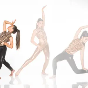 Three women posing in animal-print dancewear on white background