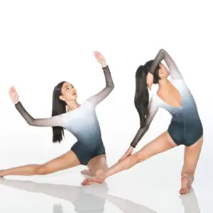 Two dancers posing in black and white leotards