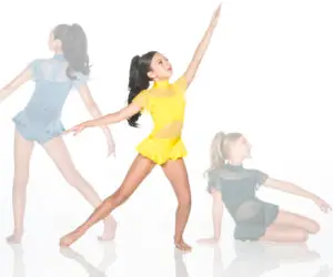 Girl in yellow dance costume poses beside faded dancers