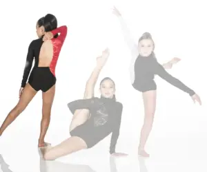 Three young dancers in leotards pose against white background.