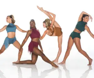 Four dancers pose in colorful dancewear against a white background.