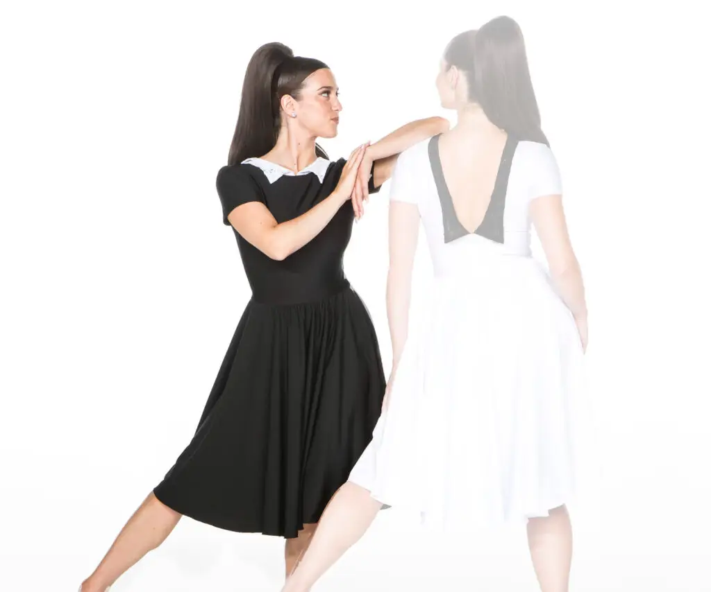 Woman in black dress beside faded reflection in white dress