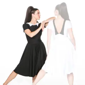 Woman in black dress beside faded reflection in white dress