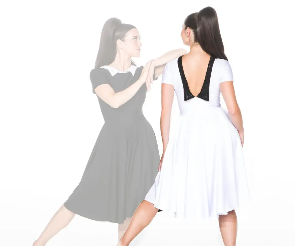 Woman wearing white dress with black back detail