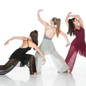 Three women in flowing dresses performing contemporary dance poses