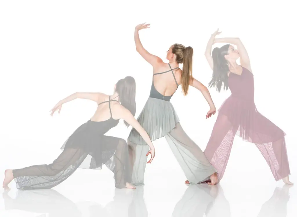 Three women performing expressive contemporary dance poses
