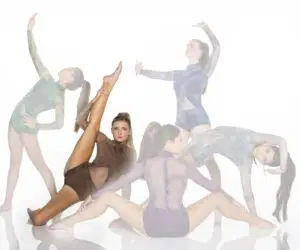 Five female dancers posing in sheer leotards on white background