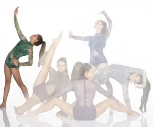 Five contemporary dancers posing in colorful leotards on white background