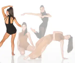 Four women pose in stylish dancewear against white background.