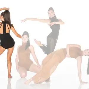 Four women pose in stylish dancewear against white background.