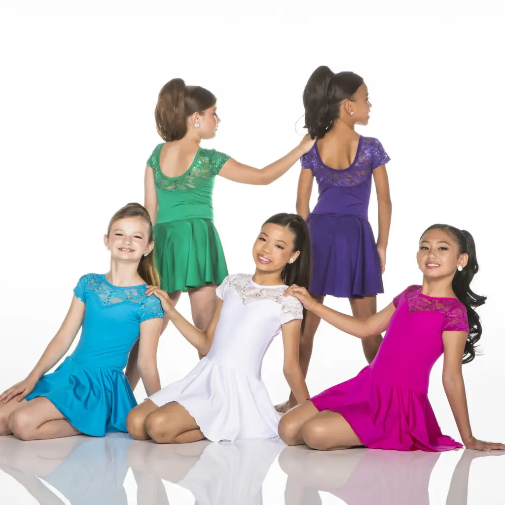 Five young dancers wearing colorful dresses pose in a studio.