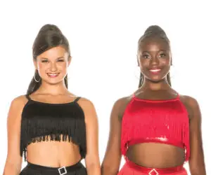 Two smiling dancers wearing black and red fringe costumes