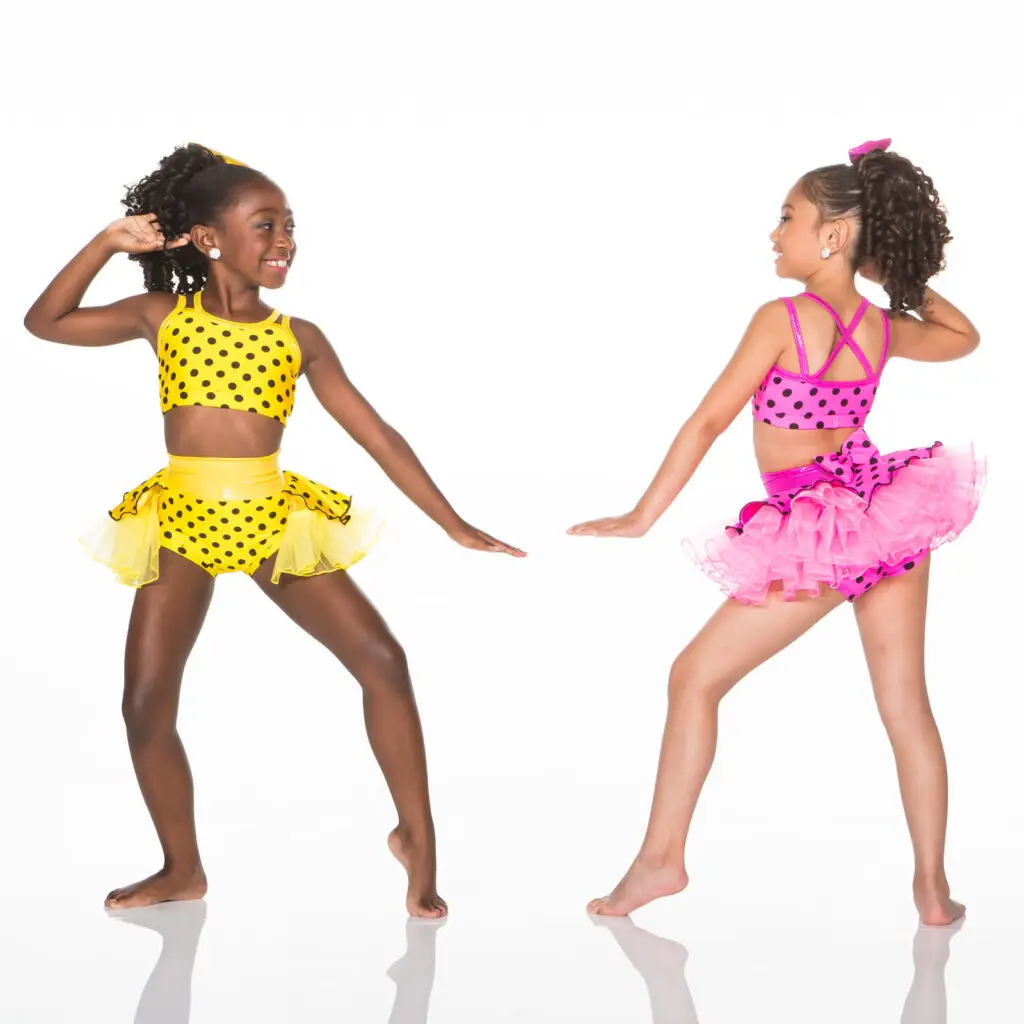 Two girls in colorful polka-dot dance costumes posing