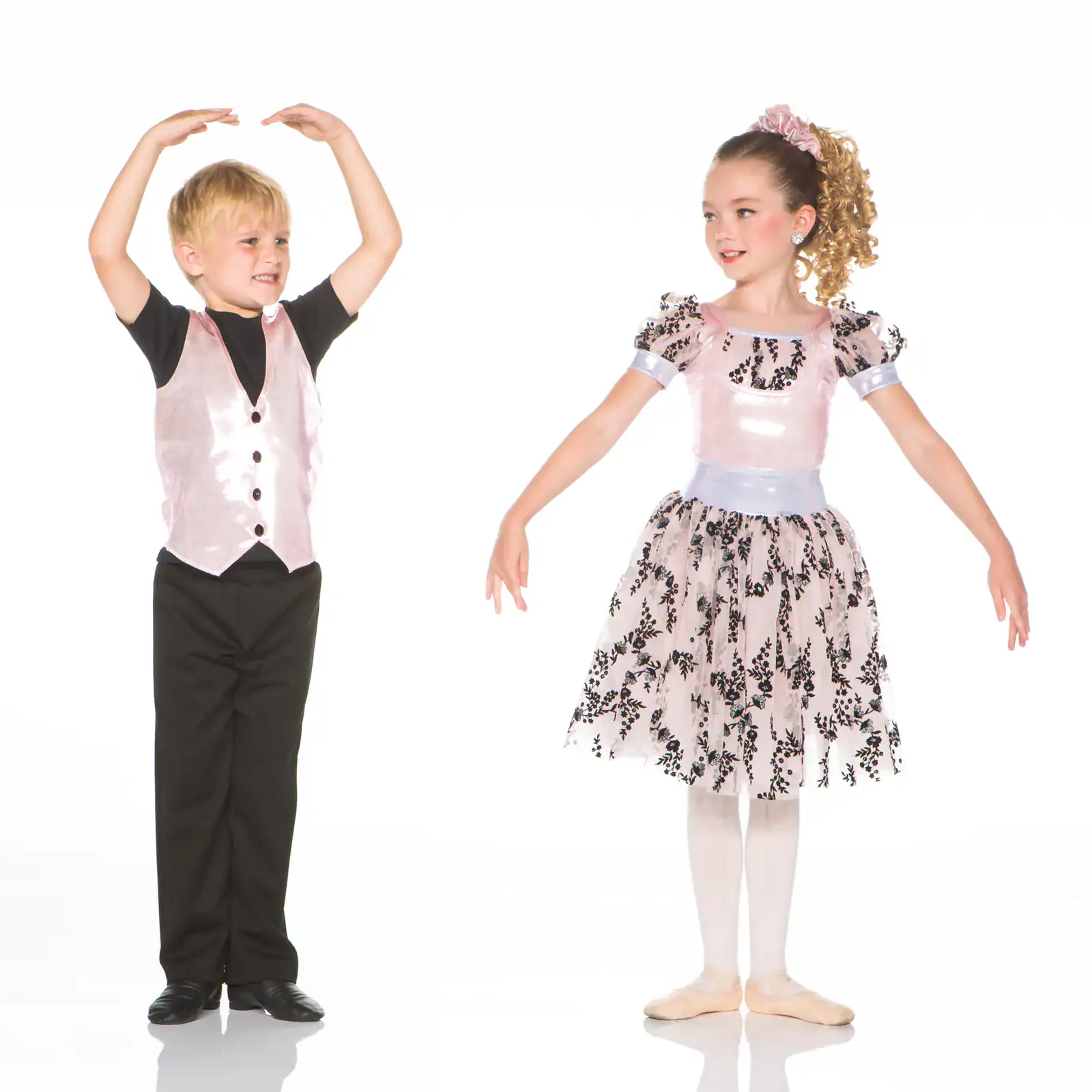 Two children in formal dance costumes posing together