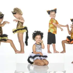 Children wearing animal-print dance costumes with ears and tails