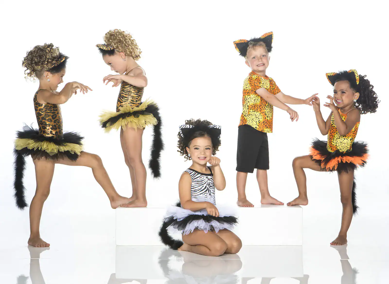 Children wearing animal-print dance costumes with ears and tails