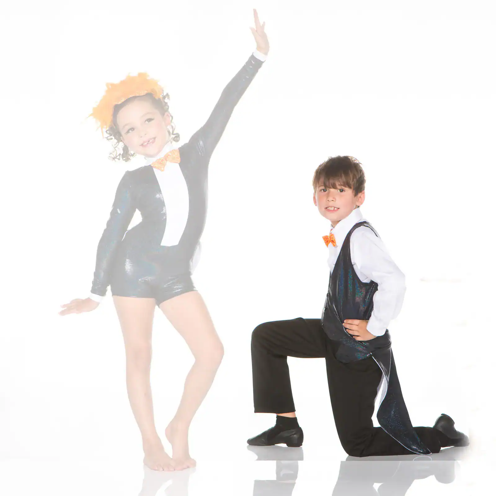 Two children pose in black-and-orange dance costumes.
