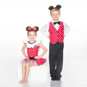 Two children wearing mouse-themed red polka-dot costumes
