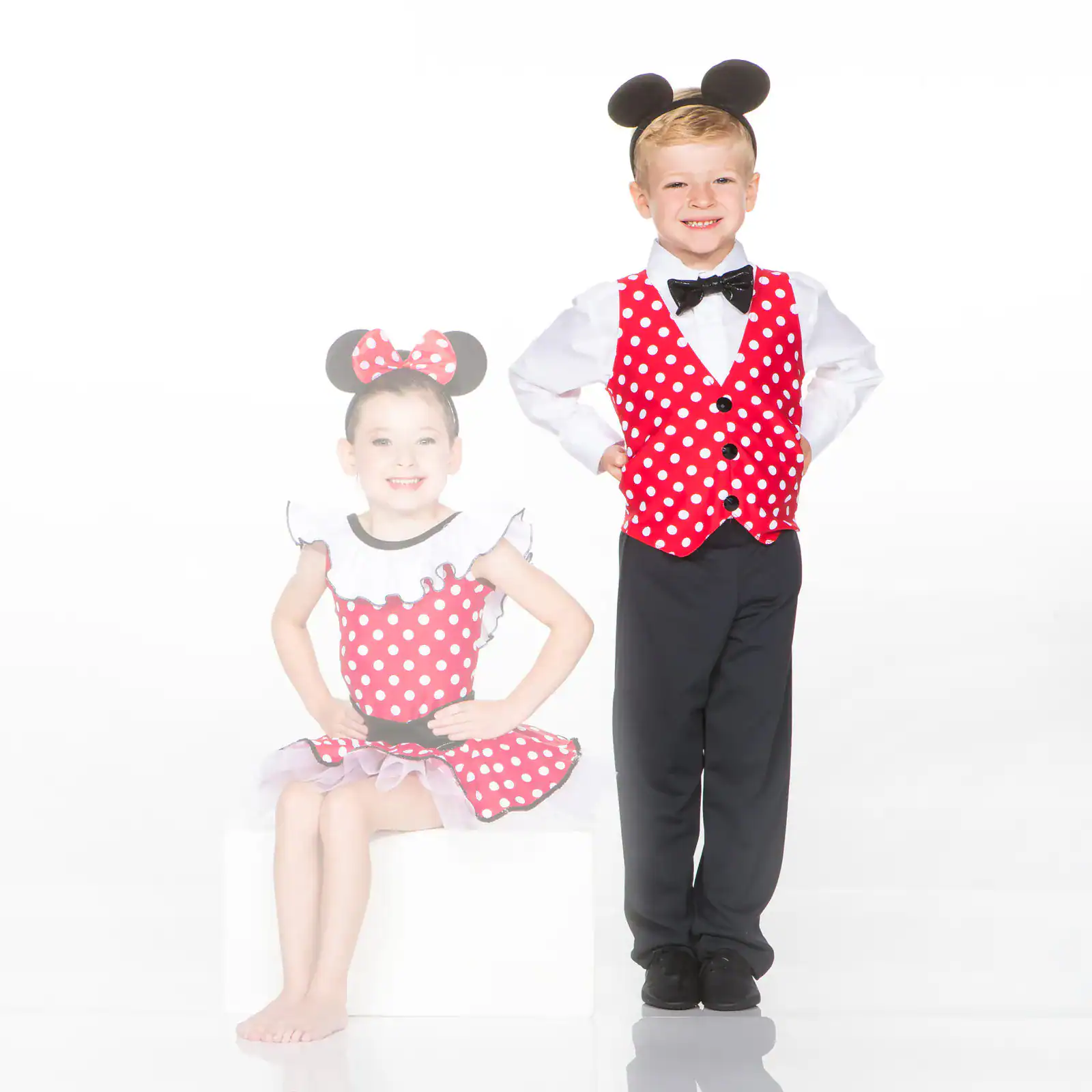 Two children wearing red polka-dot mouse costumes