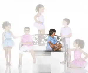 Six children in gingham outfits pose around a decorative bench.