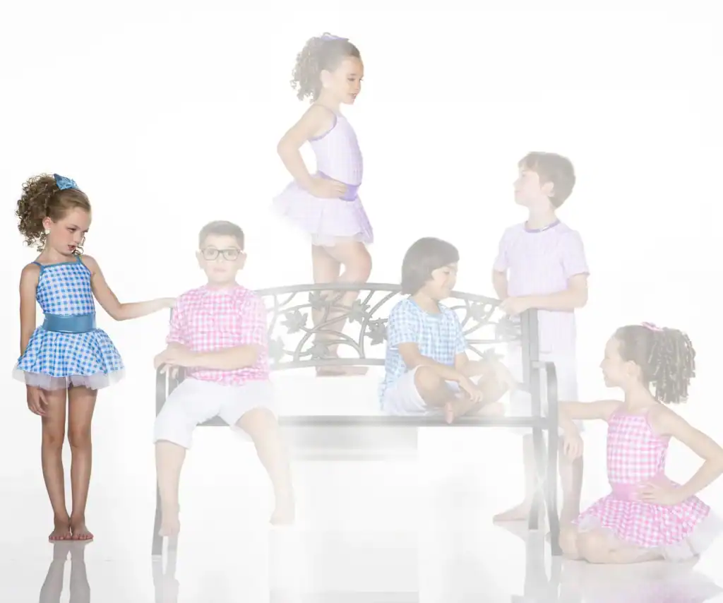 Children in colorful gingham outfits pose around a decorative bench.
