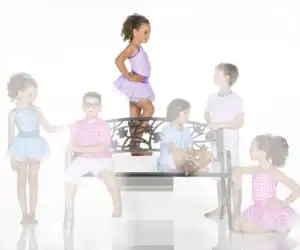 Children in colorful gingham outfits pose around decorative bench