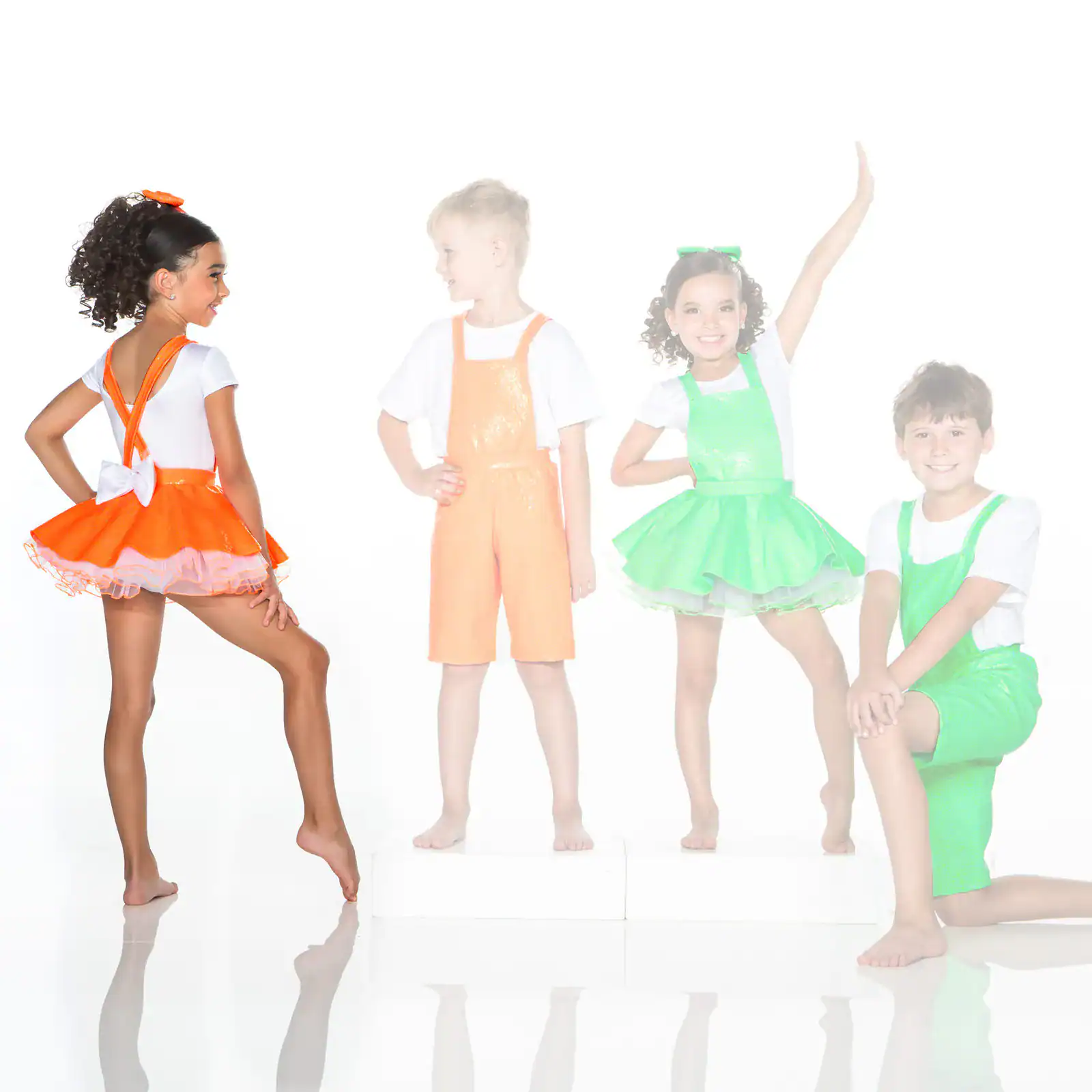 Four children wearing colorful dance costumes pose together.