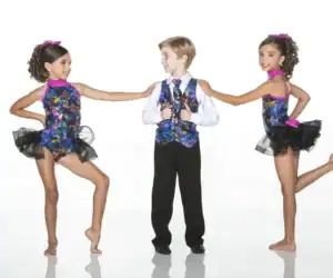Three children wearing colorful dance costumes pose together.