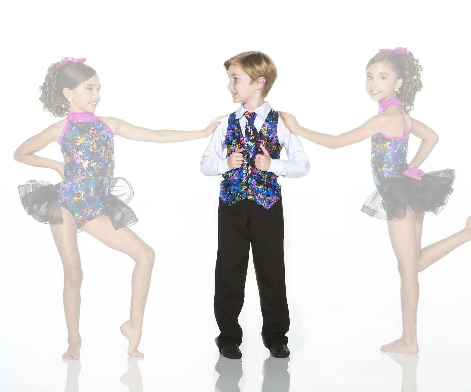 Three children in colorful dance costumes pose together.