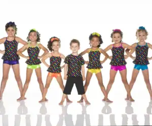 Seven children wearing colorful polka-dot dance costumes pose together.