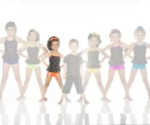 Children in colorful polka-dot dance costumes pose together