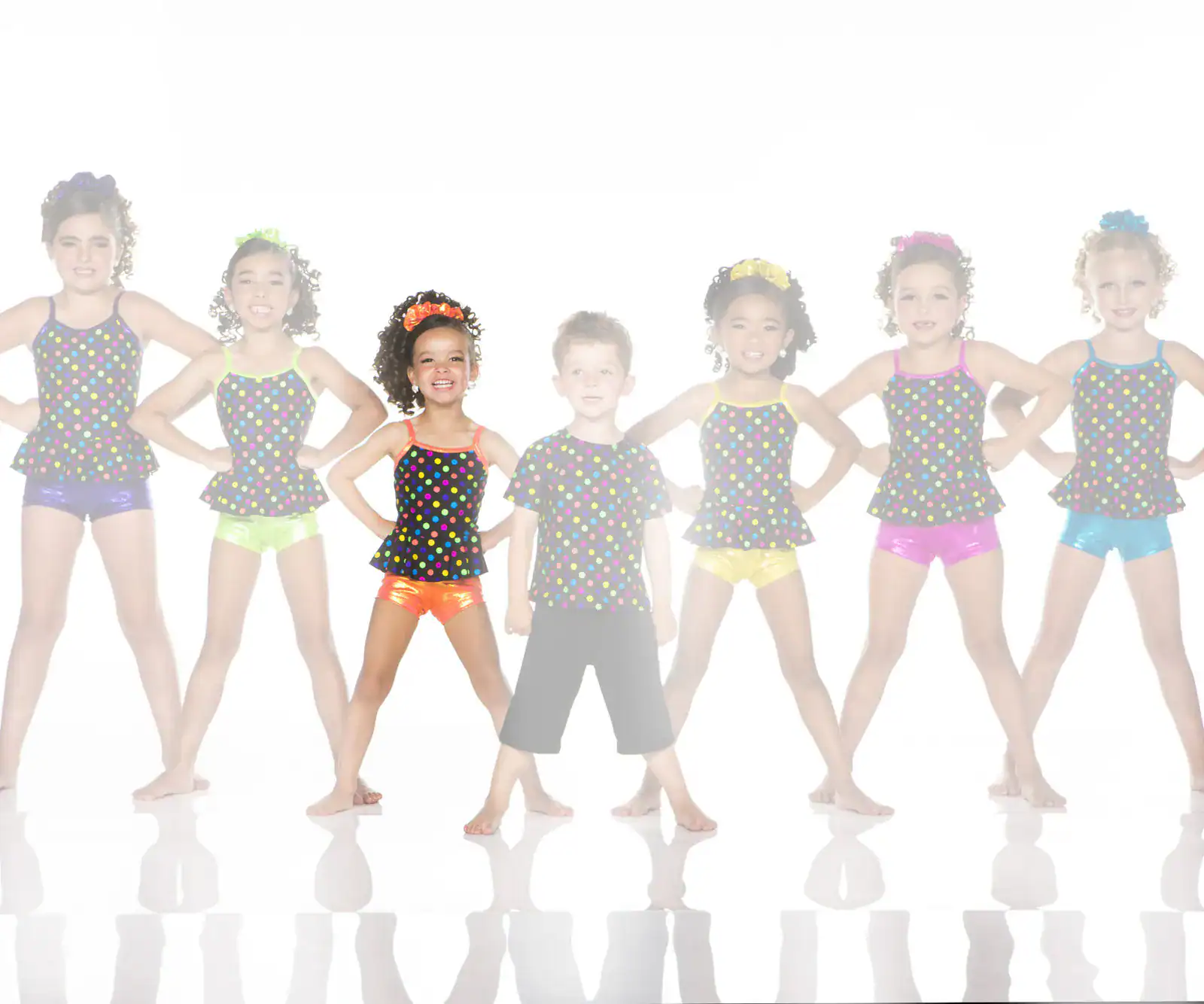 Children in colorful polka-dot dance costumes pose together