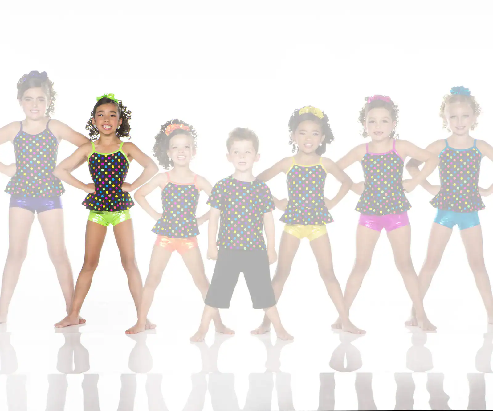 Seven children in colorful polka-dot dance costumes posing together