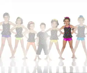 Seven children in colorful polka-dot dance costumes posing