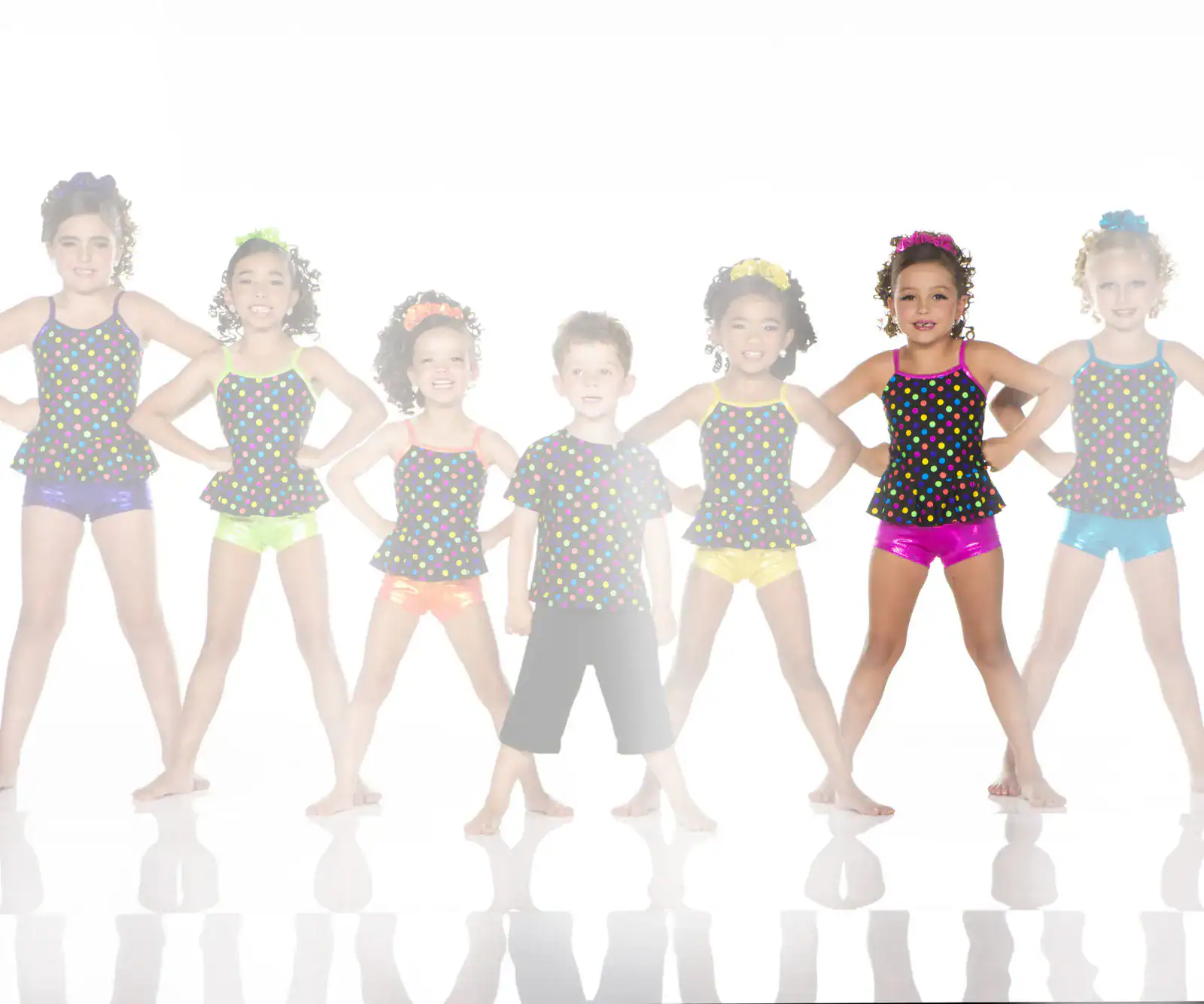 Seven children in colorful polka-dot dance costumes posing
