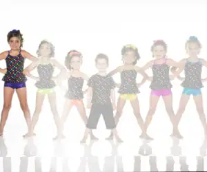 Children posing in colorful polka-dot dance costumes