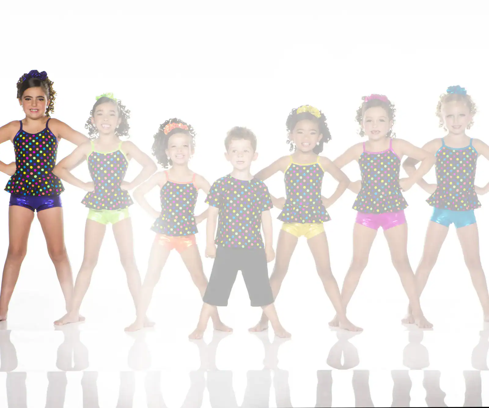 Children posing in colorful polka-dot dance costumes