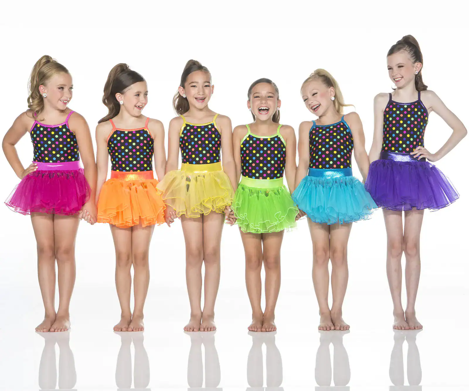 Six young dancers in colorful polka-dot costumes and tutus