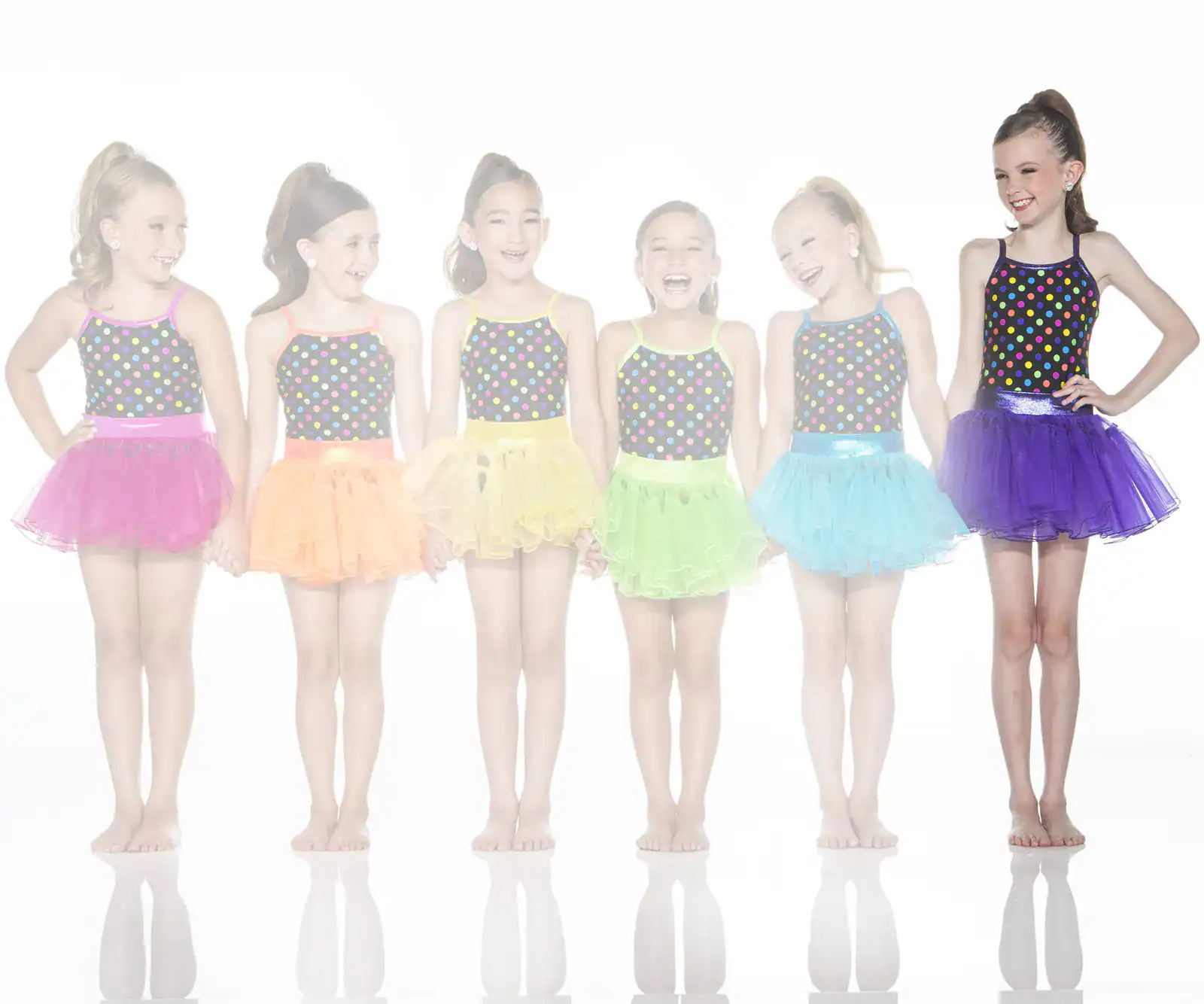 Six girls wearing colorful polka-dot dance costumes and tutus