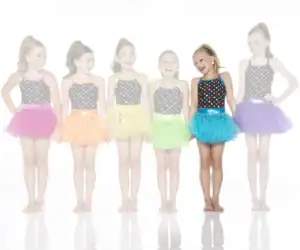 Six young dancers wearing colorful polka-dot costumes and tutus