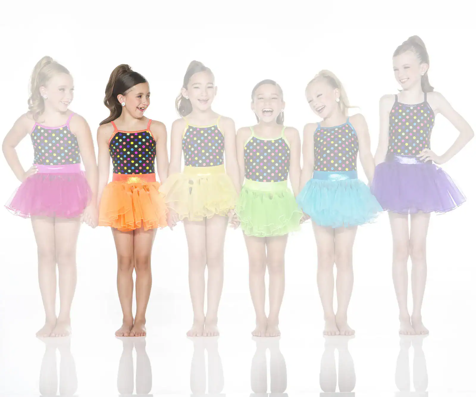 Six girls wearing colorful polka-dot dance costumes and tutus