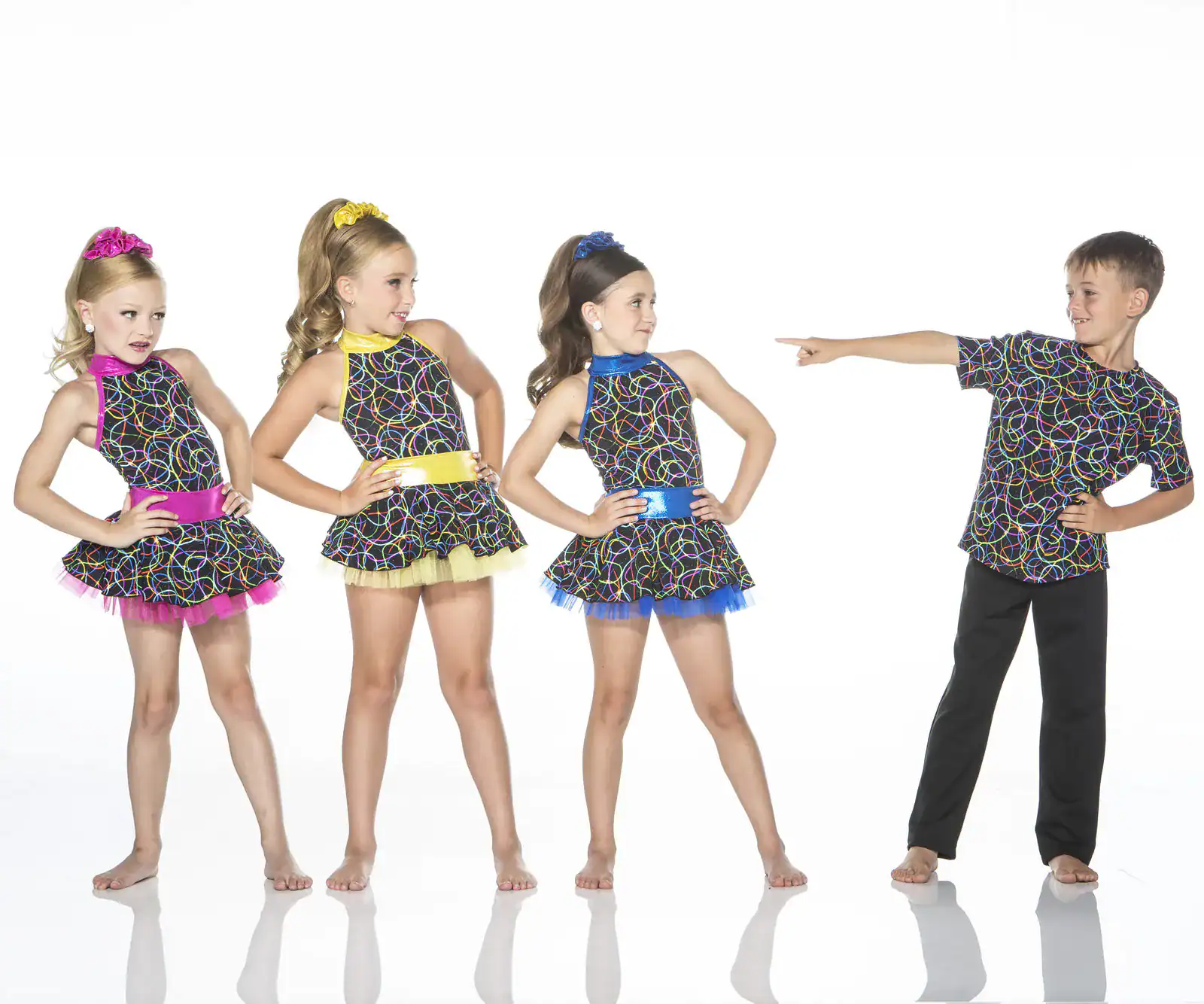 Four children wearing colorful patterned dance costumes