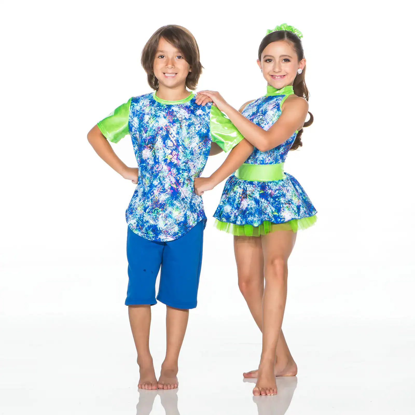 Two children wearing matching blue and green dance costumes