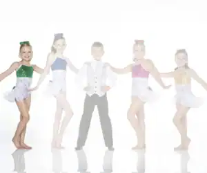 Five young dancers in sparkling costumes pose together.