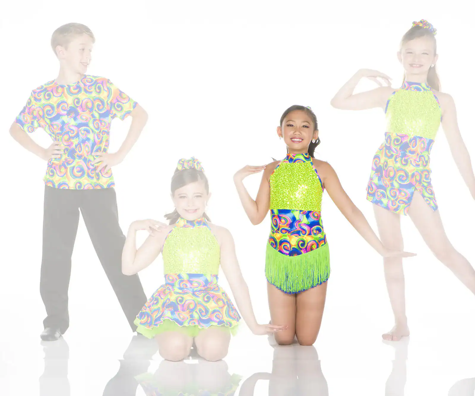 Four young dancers pose in colorful swirl-patterned costumes.