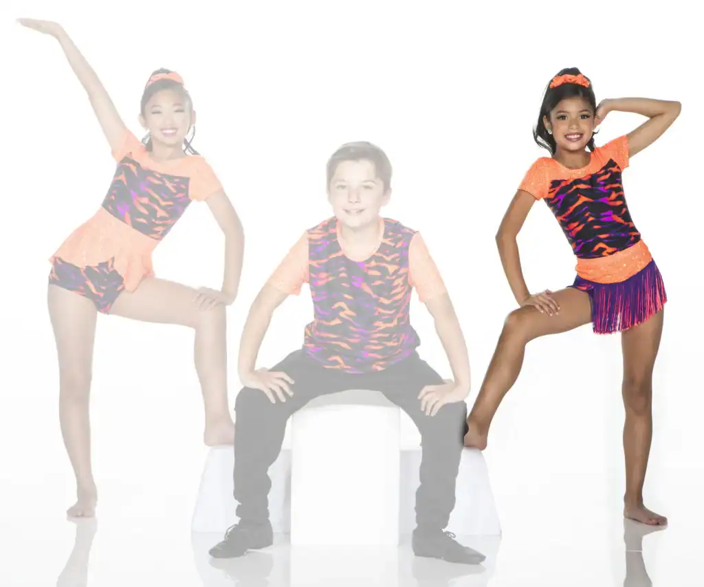 Three young dancers posing in colorful orange and patterned costumes